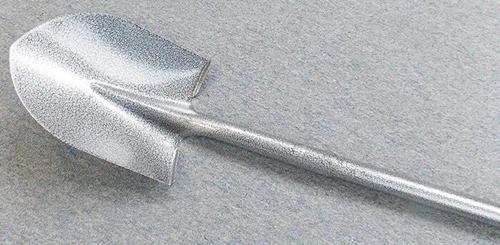 Shovel with a metallic, textured surface on a smooth gray background for NIS Tools SEO branding.