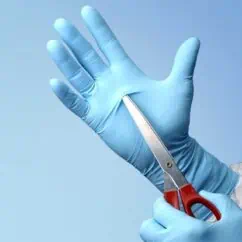 Sterile medical gloves and scissors for safe surgical procedures or medical disinfection. Healthcare workers use these tools to ensure hygiene and safety in medical environments.
