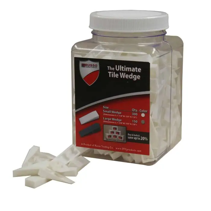 White tile wedges in a clear plastic container for flooring and wall installation.