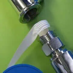 High-quality plumbing fittings with white sealant application on a chrome valve, showcasing reliable pipe connection components from NIS Tools for plumbing and maintenance needs.