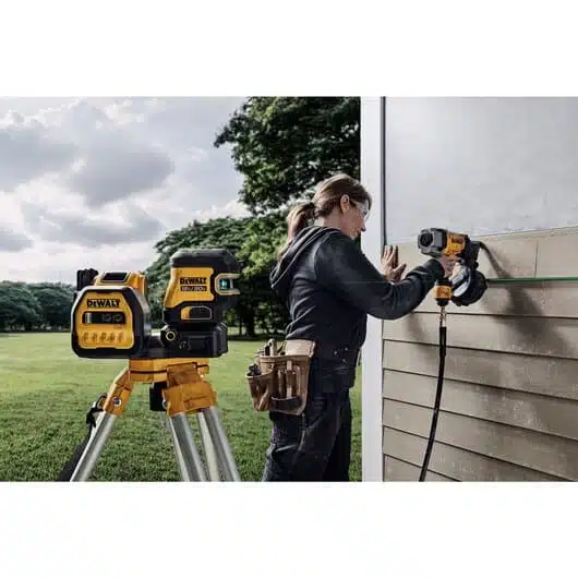 DeWalt laser level and cordless drill for outdoor construction, precision measurement for siding installation. Reliable tools for professional builders and homeowners.
