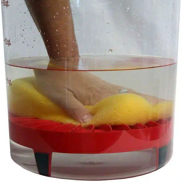 Soaking yellow sponge with hand in red cleaning basin - NIS Tools cleaning and kitchen supplies.